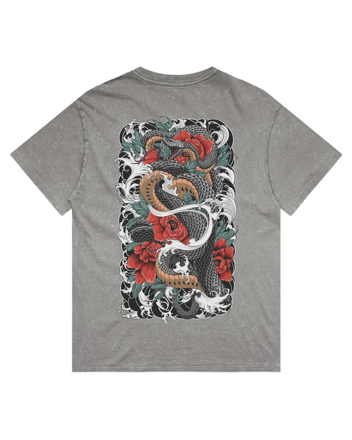 A grey stonewash short-sleeve t-shirt shown from the back, featuring a large rectangular graphic print of a traditional Japanese tattoo style design with a black and white snake, red roses, and green leaves.