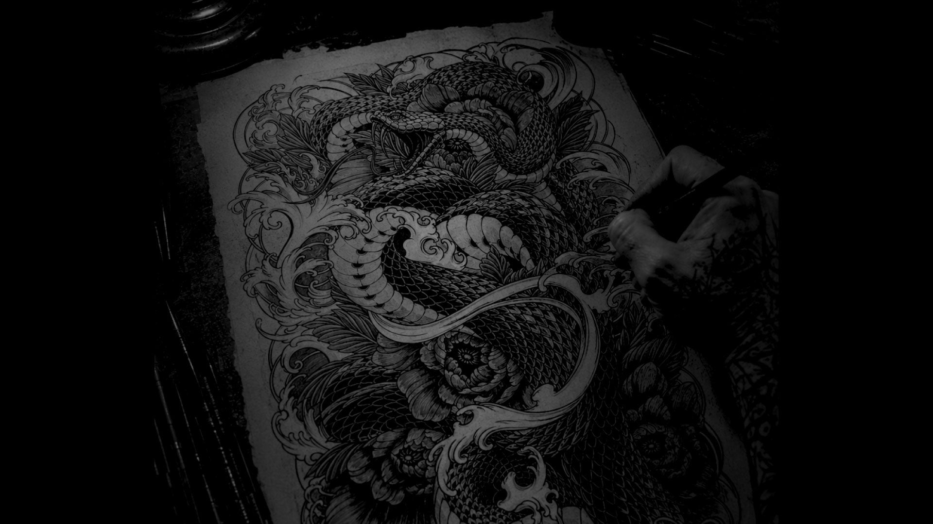 Detailed black and white direzumi snake sketch on a person's sketch book.