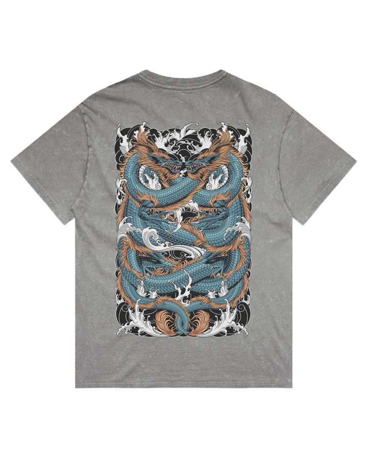 A grey stonewash short-sleeve t-shirt shown from the back, featuring a large graphic print of two intertwined koi fish swimming through stylized waves. The fish are detailed in shades of teal blue, brown, and white, set against a black and white wave background.
